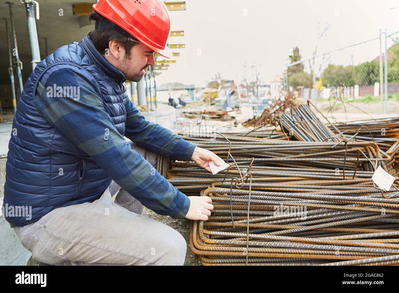Il caposquadra del cantiere nella conchiglia dell'edificio controlla la qualità della fornitura del ferro di rinforzo Foto Stock