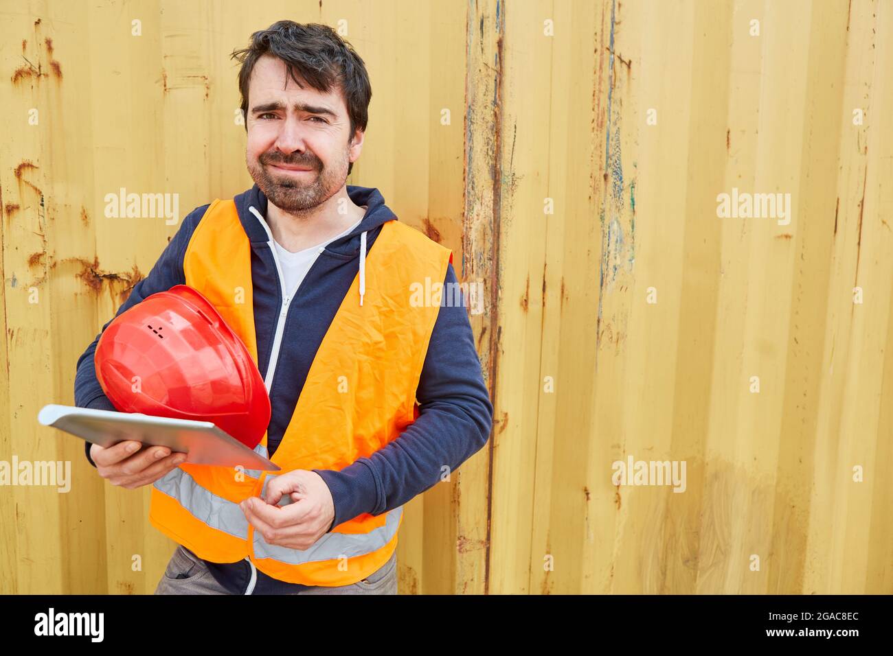 Lavoratore di costruzione o artigiano che utilizza un computer tablet quando si pianifica un progetto di costruzione Foto Stock