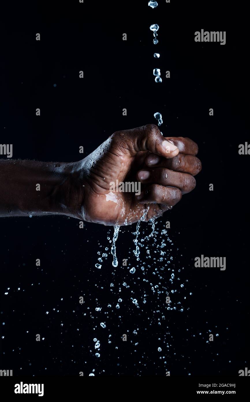 L'uomo africano interagisce con l'acqua. Foto Stock