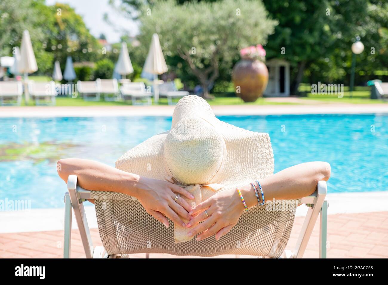 Giovane donna bionda che si rilassa in piscina presso il resort termale - concetto rilassante Foto Stock