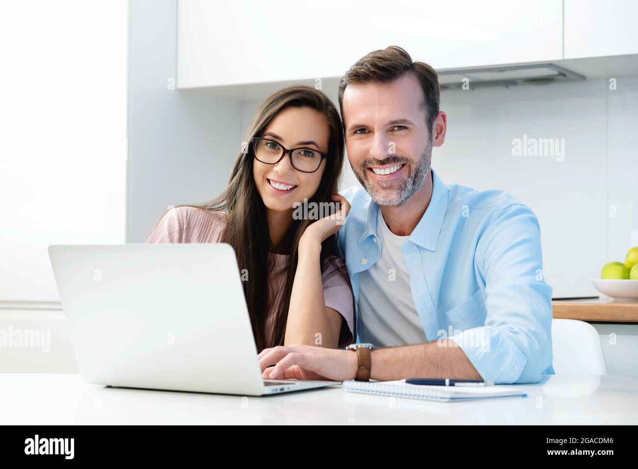 Coppia sorridente seduto al computer. Concetto finanziario, bel sorriso bianco Foto Stock