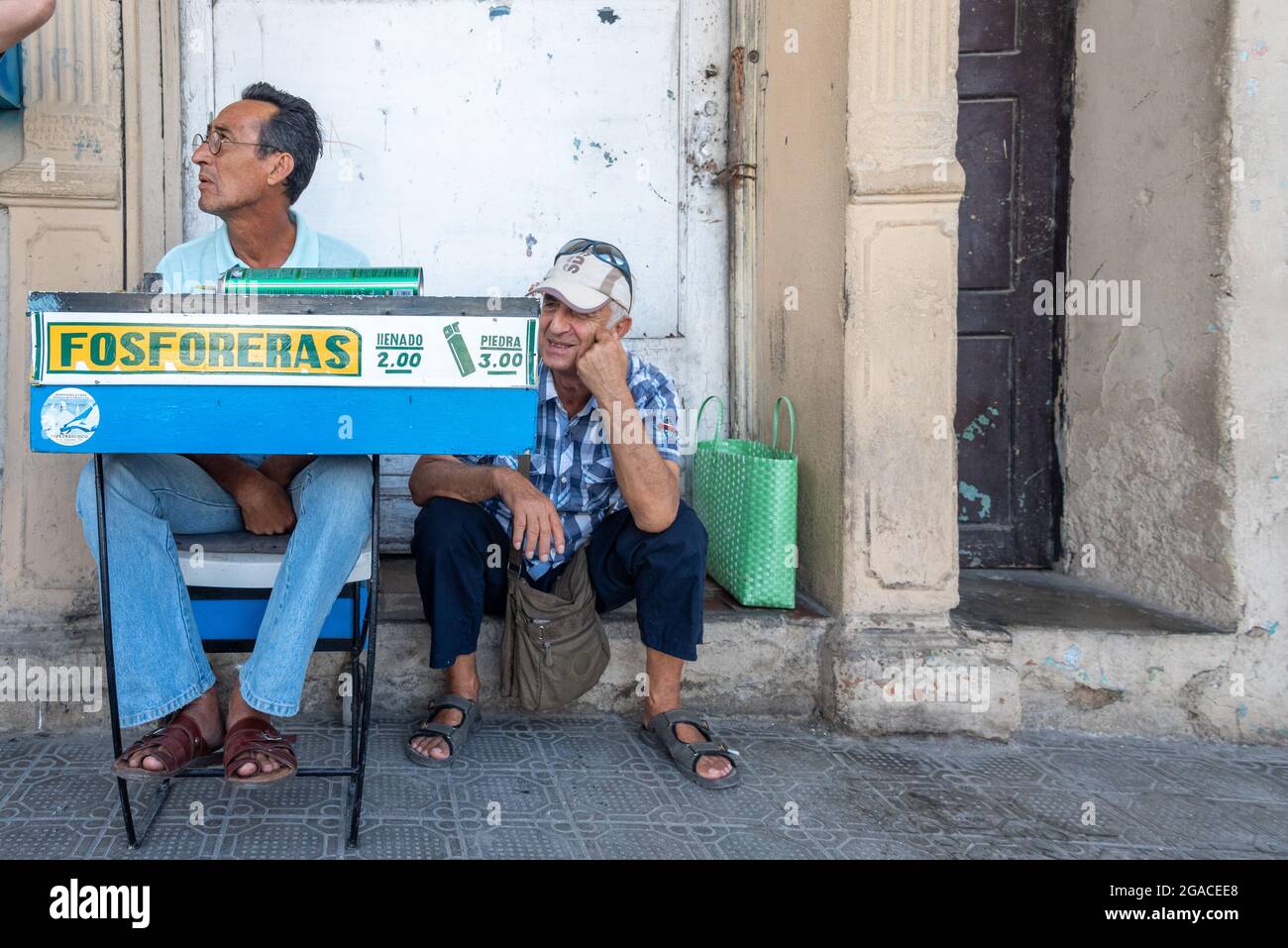 Tavolo dell'uomo cubano autonomo che ricarica accendini, Holguin City Travel, Cuba, 2016 Foto Stock