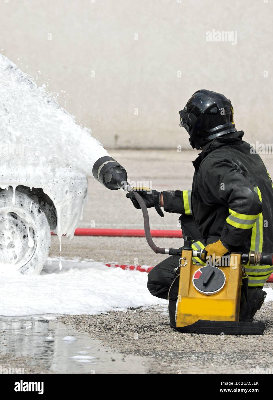un pompiere coraggioso che spegne un incendio di un'auto utilizzando una  speciale schiuma ignifuga bianca Foto stock - Alamy