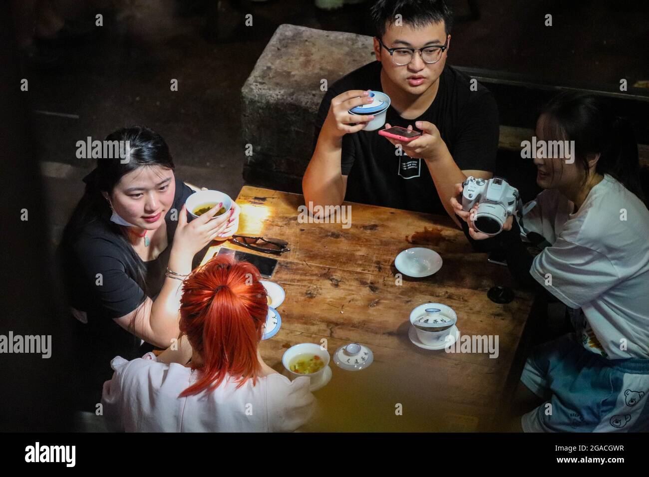 (210730) -- CHONGQING, 30 luglio 2021 (Xinhua) -- la gente chiacchiera mentre beve il tè alla teahhouse di comunicazioni nel Chongqing del sud-ovest della Cina, 26 luglio 2021. Chen Anjian, 62 anni, insegnante di pittura ad olio presso il Sichuan fine Arts Institute, frequenta la Chongqing Communications Teahhouse per più di 20 anni. Fondata nel 1987, la sala da tè Communications è ora l'unica vecchia casa da tè di Chongqing che ha mantenuto lo stile originale degli anni '70 e '80. E' uno dei punti di riferimento culturali chiave di Chongqing, e visitato ogni giorno da migliaia di amanti del tè. "La Teahhouse delle Comunicazioni è la Th Foto Stock