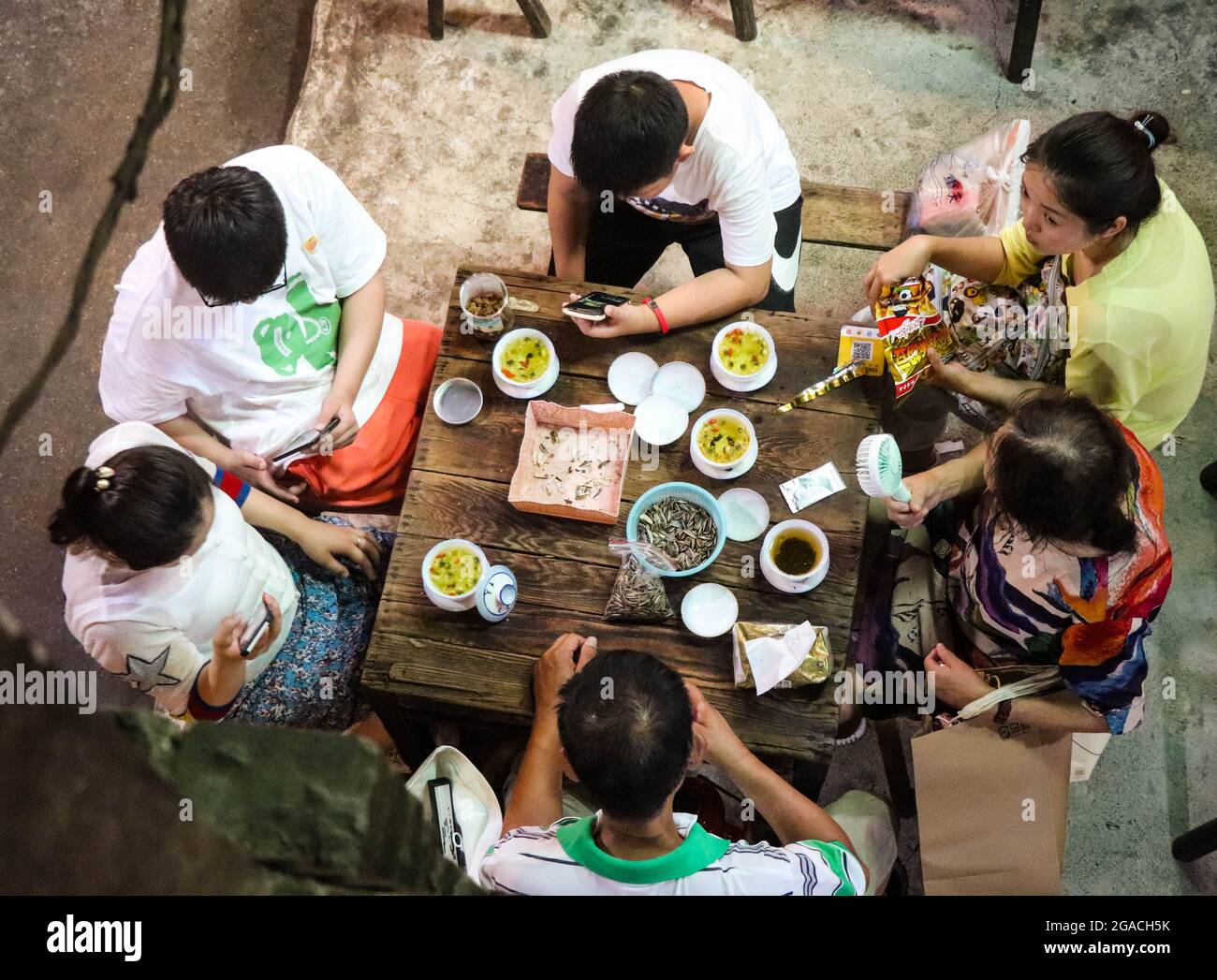 (210730) -- CHONGQING, 30 luglio 2021 (Xinhua) -- la gente chiacchiera mentre beve il tè alla teahhouse di comunicazioni nel Chongqing del sud-ovest della Cina, 26 luglio 2021. Chen Anjian, 62 anni, insegnante di pittura ad olio presso il Sichuan fine Arts Institute, frequenta la Chongqing Communications Teahhouse per più di 20 anni. Fondata nel 1987, la sala da tè Communications è ora l'unica vecchia casa da tè di Chongqing che ha mantenuto lo stile originale degli anni '70 e '80. E' uno dei punti di riferimento culturali chiave di Chongqing, e visitato ogni giorno da migliaia di amanti del tè. "La Teahhouse delle Comunicazioni è la Th Foto Stock