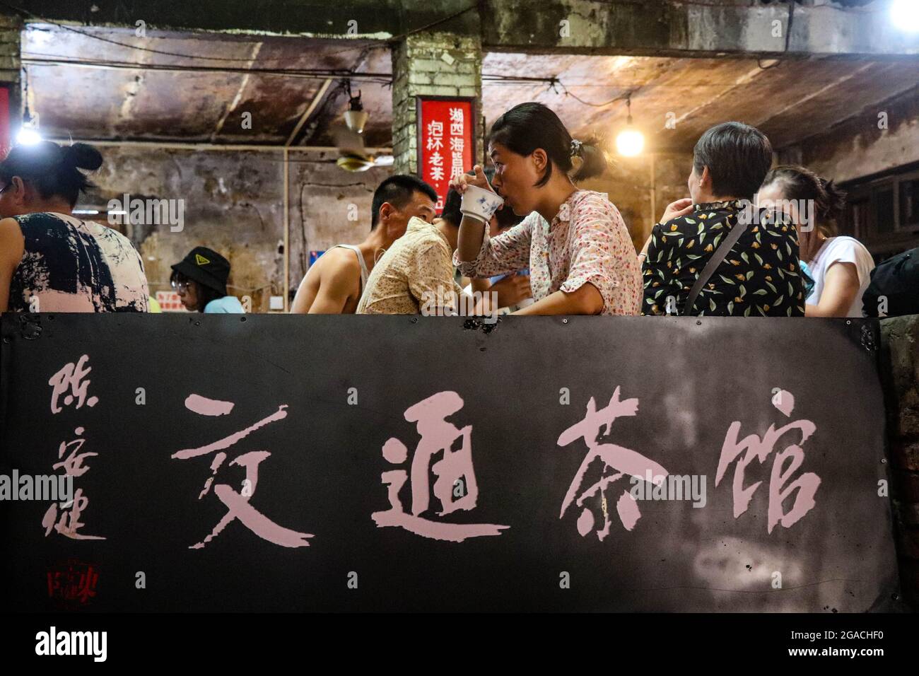 (210730) -- CHONGQING, 30 luglio 2021 (Xinhua) -- la gente chiacchiera mentre beve il tè alla teahhouse di comunicazioni nel Chongqing del sud-ovest della Cina, 26 luglio 2021. Chen Anjian, 62 anni, insegnante di pittura ad olio presso il Sichuan fine Arts Institute, frequenta la Chongqing Communications Teahhouse per più di 20 anni. Fondata nel 1987, la sala da tè Communications è ora l'unica vecchia casa da tè di Chongqing che ha mantenuto lo stile originale degli anni '70 e '80. E' uno dei punti di riferimento culturali chiave di Chongqing, e visitato ogni giorno da migliaia di amanti del tè. "La Teahhouse delle Comunicazioni è la Th Foto Stock
