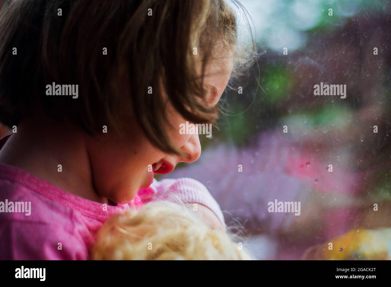 bambina che guarda fuori la finestra della sua casa. Fuoco selettivo ragazza. Foto Stock