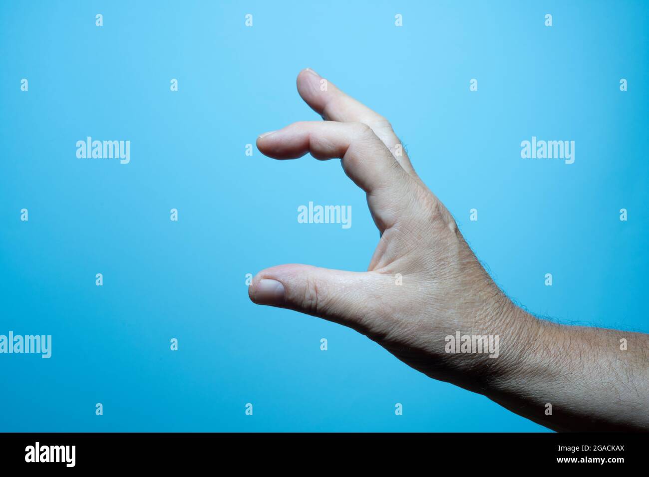 le dita di una mano maschio con sfondo blu Foto Stock