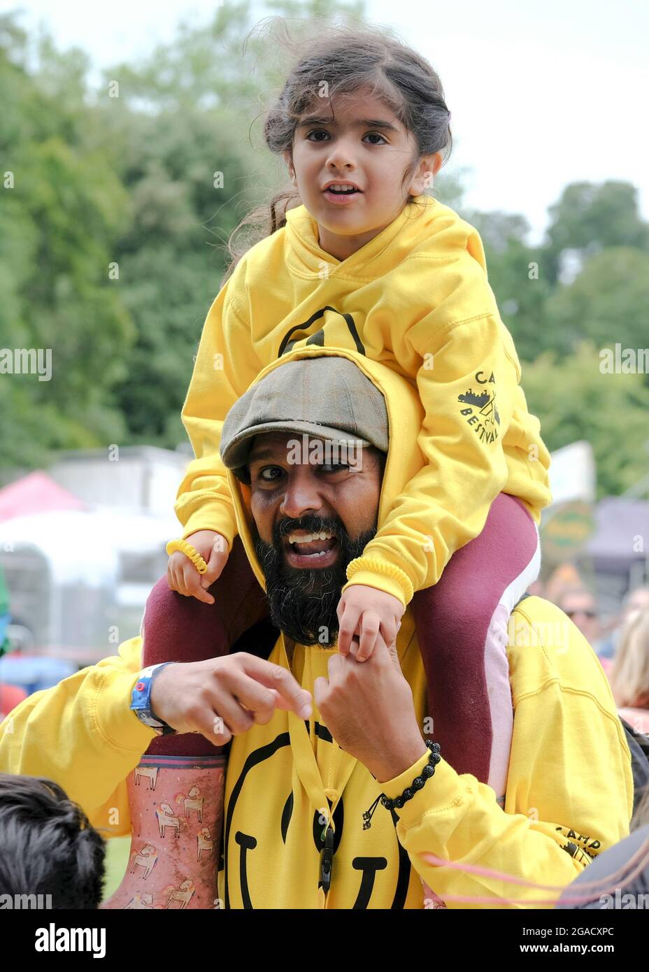 Lulworth, Dorset, 30 luglio 2021, sorridente padre con figlia sulle spalle a Camp Bestival, Lulworth, Dorset UK Credit: Dawn Fletcher-Park/Alamy Live News Foto Stock