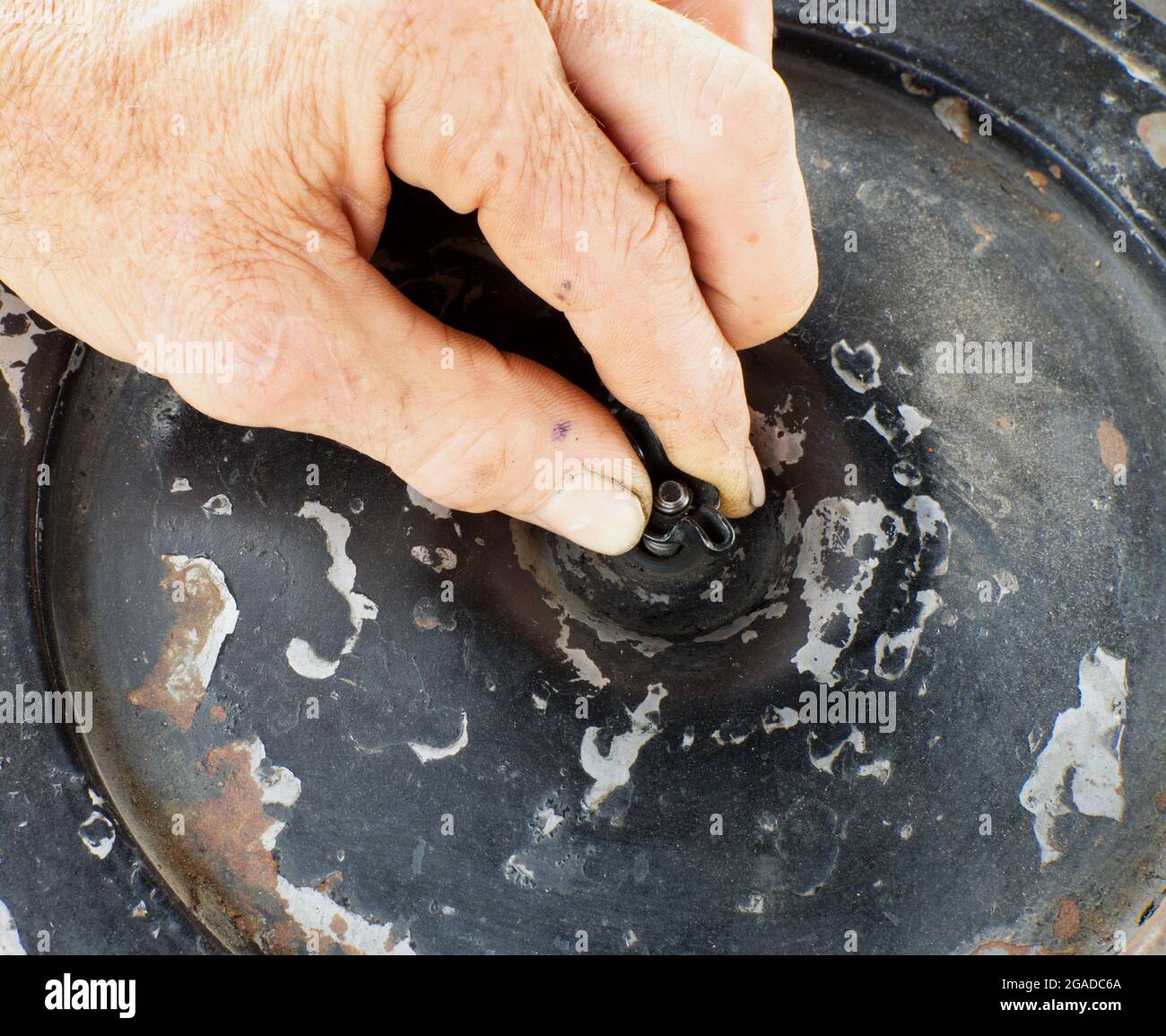Una vista ad alto angolo di un meccanico che serra un dado ad alette Foto Stock Una vista ad alto angolo di un meccanico che serra un dado ad alette Foto Stock