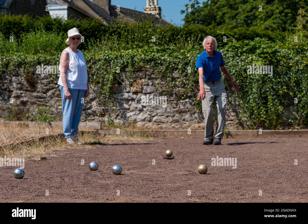 Anziani, anziani o pensionati che giocano a bocce o bocce al sole d'estate, Haddington, East Lothian, Scozia, Regno Unito Foto Stock