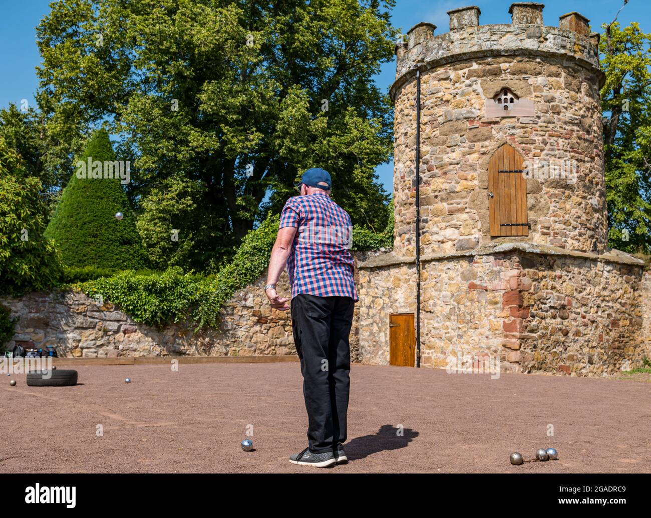 Anziano, anziano o pensionato che gioca a bocce o bocce al sole d'estate, Haddington, East Lothian, Scozia, Regno Unito Foto Stock