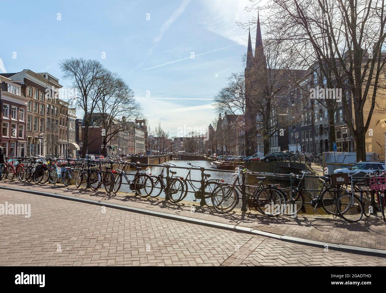 Biciclette a Heibrug (Brug 4), Wijde Heisteeg, attraverso il canale Singel, con De Krijtberg Kerk sullo sfondo, Amsterdam, Paesi Bassi Foto Stock