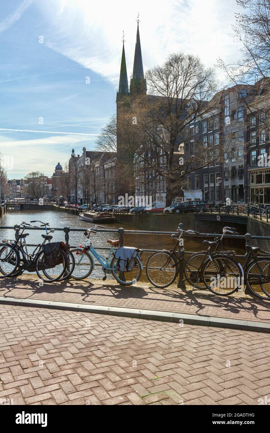 Biciclette a Heibrug (Brug 4), Wijde Heisteeg, attraverso il canale Singel, con De Krijtberg Kerk sullo sfondo, Amsterdam, Paesi Bassi Foto Stock