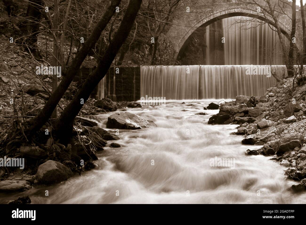 Versione artistica delle doppie cascate e del ponte di pietra di Paleokaria, nella regione di Trikala, Tessaglia, Grecia, Europa. Foto Stock