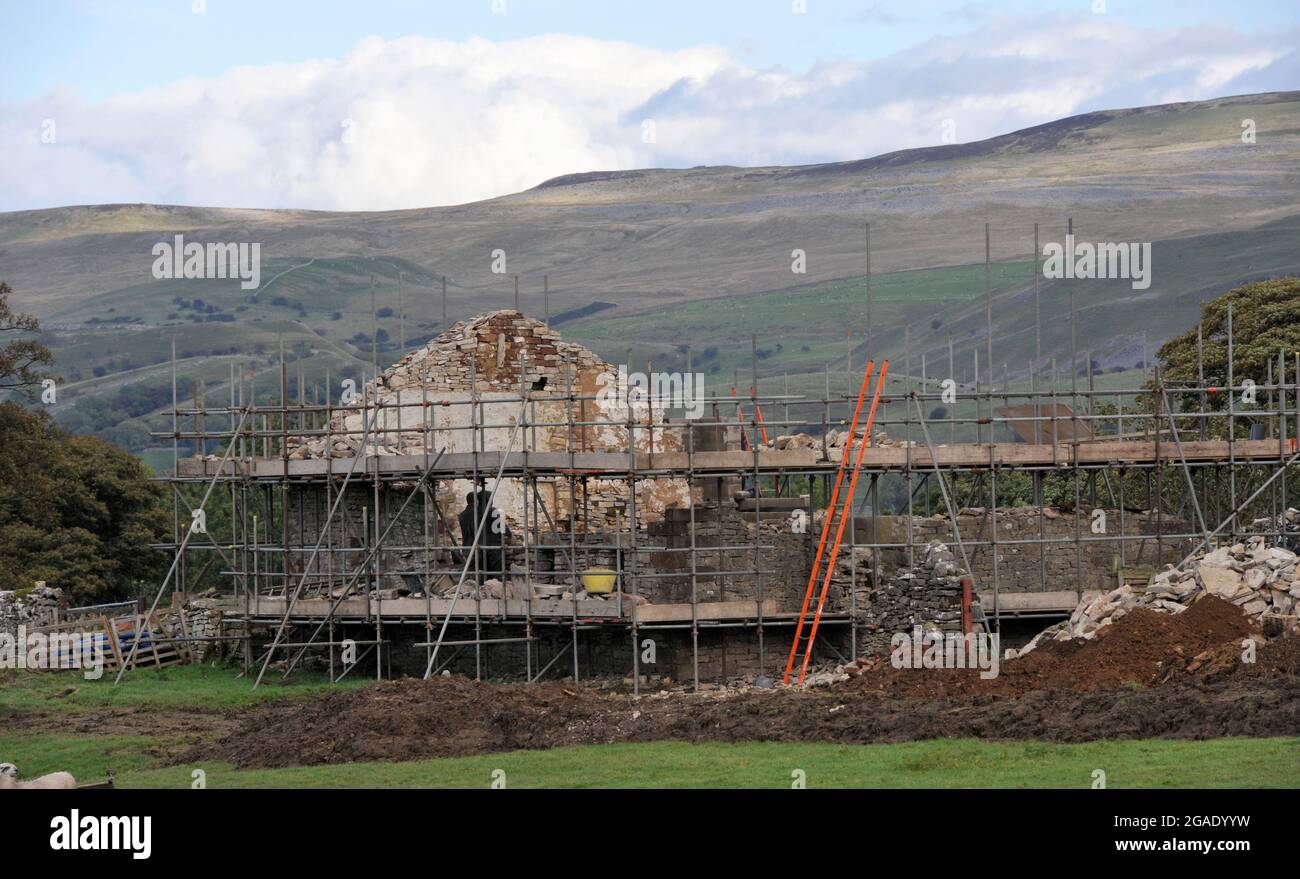 Vecchio fienile di pietra su una fattoria collina che viene tolto e ricostruito come una casa di vacanza, Cumbria, Regno Unito. Foto Stock
