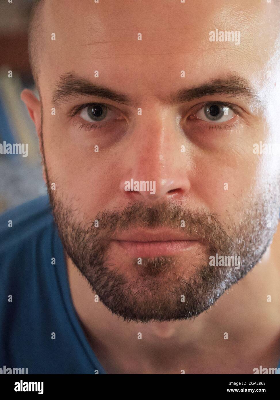 Lo sguardo di un uomo bianco. Verticale, primo piano. Un uomo con una stoppia sul viso. Foto Stock