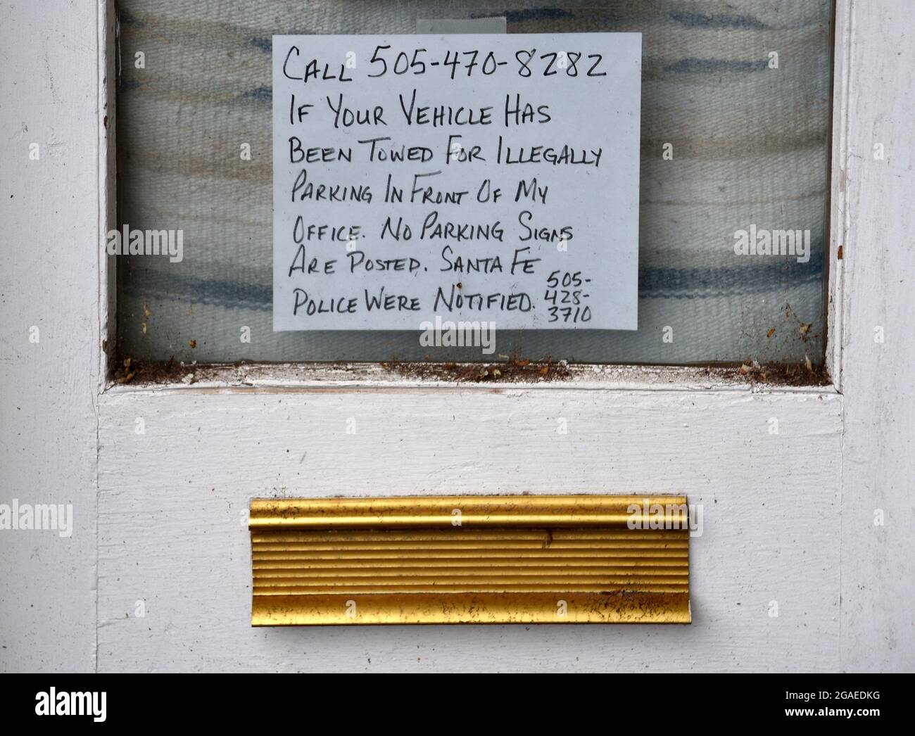 Un segno scritto a mano postato sulla porta d'ingresso di un ufficio di chiropractor a Santa Fe, New Mexico, avverte gli automobilisti di non parcheggiare di fronte alla sua attività. Foto Stock