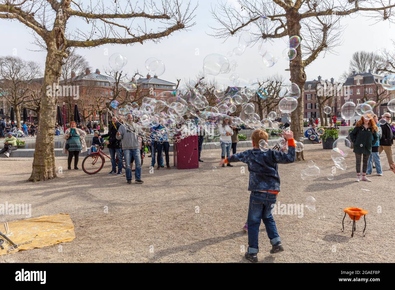 Bambini che giocano con le bolle di sapone in Piazza Museo, Amsterdam Foto Stock