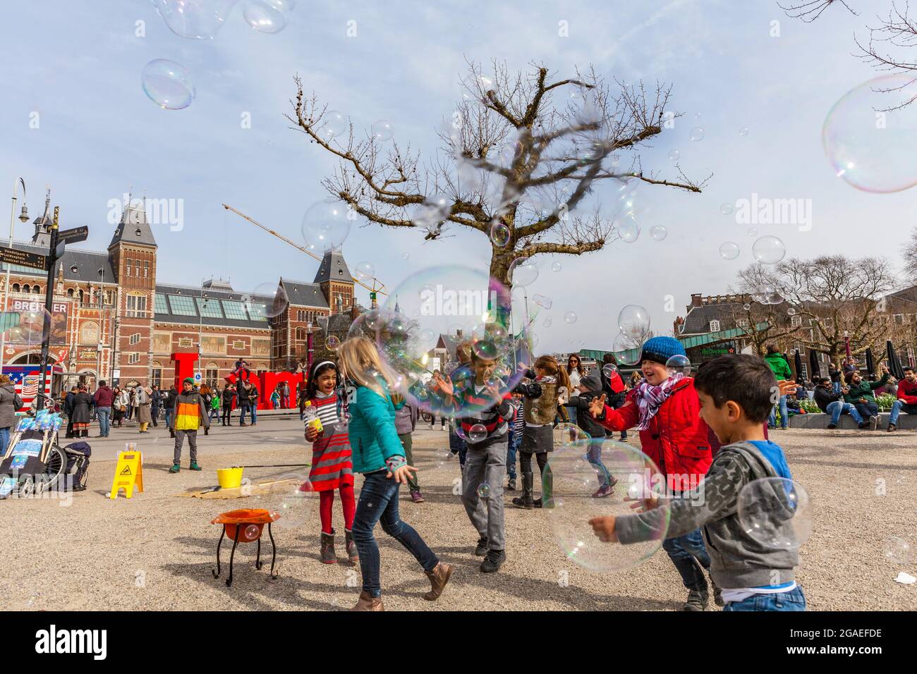 Bambini che giocano con le bolle di sapone in Piazza Museo, Amsterdam Foto Stock