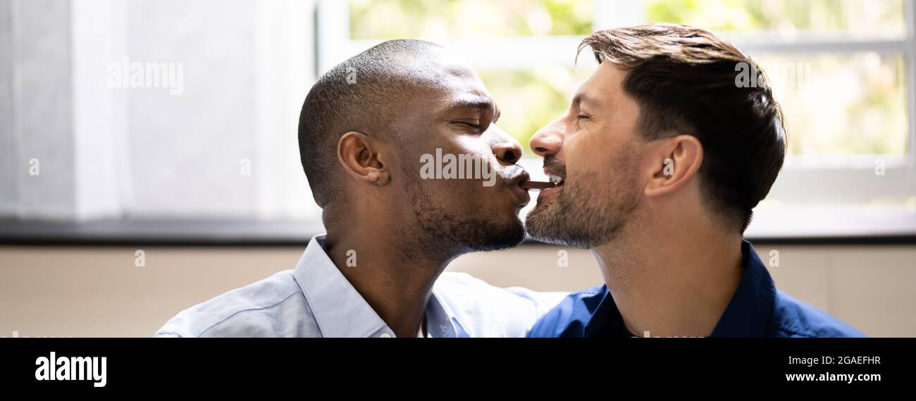 Data romantica. Happy Gay coppia che condividono snack Foto Stock