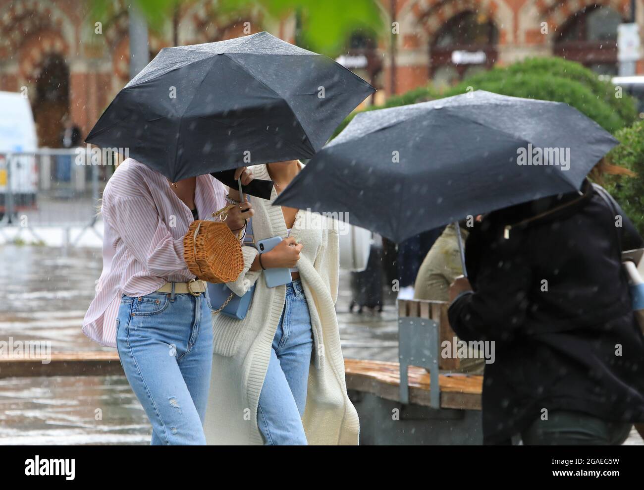 Londra, Regno Unito 30 luglio 2021. Frequenti docce a pioggia significavano che un ombrello pratico veniva in utile a Kings Cross/St Pancras, Londra, Regno Unito. Dal 9 agosto si promette un clima più asciutto e sunnier. Monica Wells/Alamy Live News Foto Stock