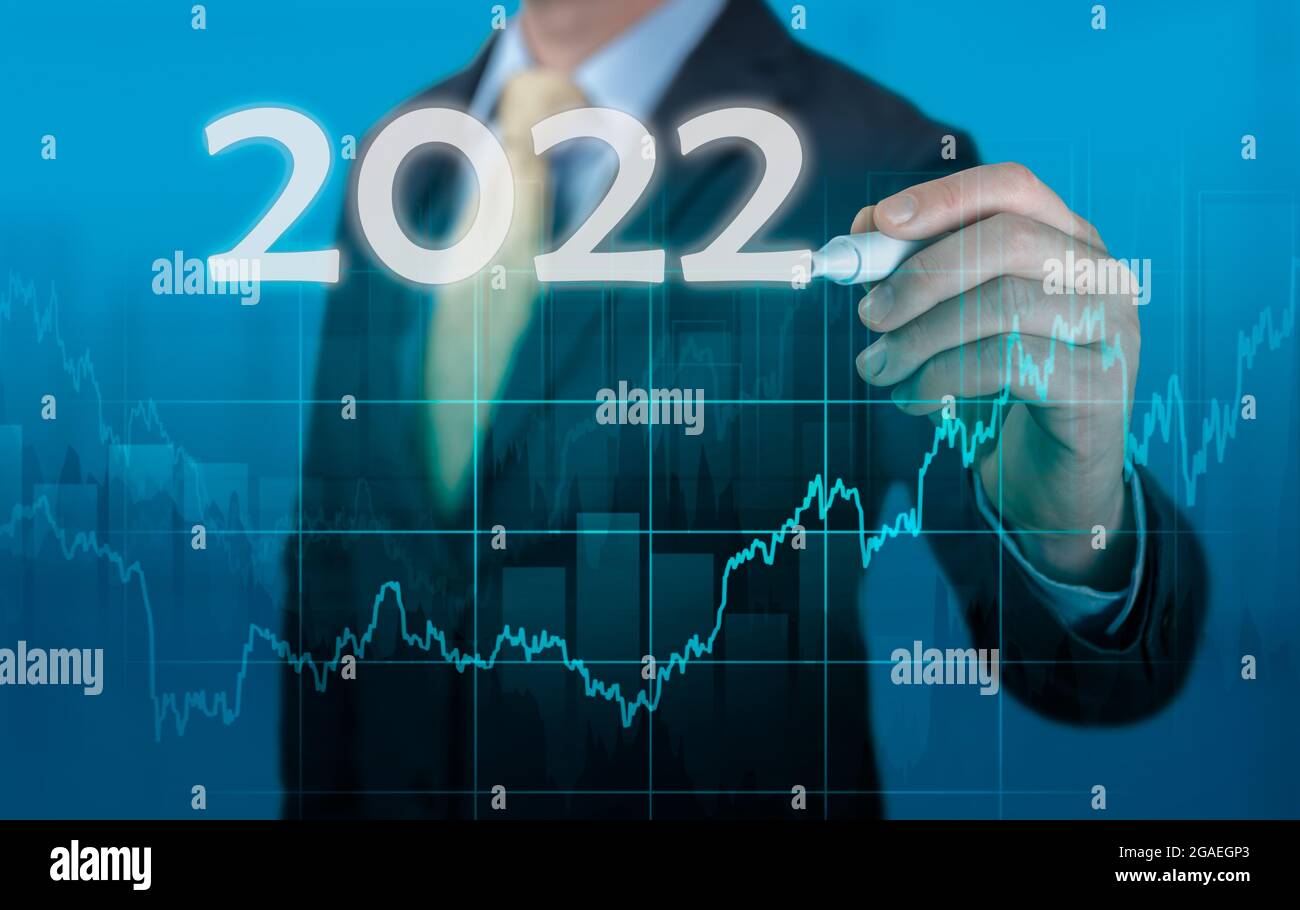 Businessman in suit previsione analisi piano profit chart. Previsioni economiche per 2022. Businessman scrive 2022 su schermo virtuale. Ripresa economica a poppa Foto Stock