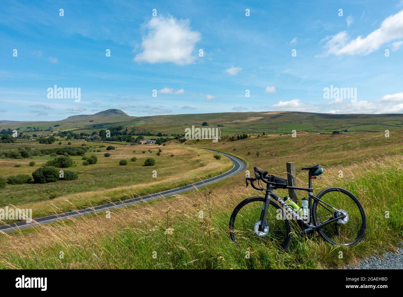 Vista in bicicletta di Pen-y-ghent da Stainforth Lane e Austwick Road in condizioni meteorologiche eccezionali con una bici da strada, Austwick, Yorkshire Dales National Park. REGNO UNITO L Foto Stock