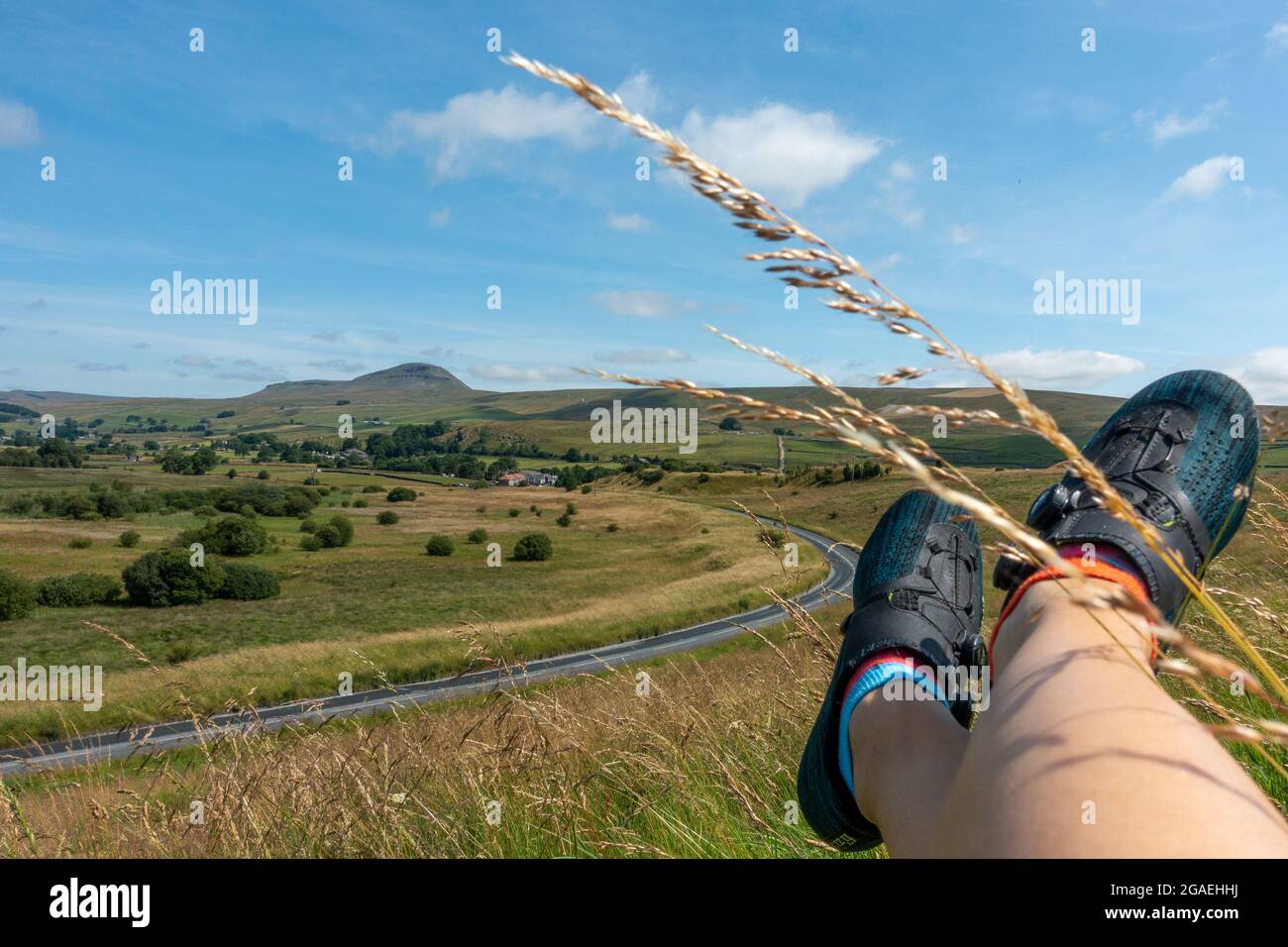 Vista in bicicletta di Pen-y-ghent da Stainforth Lane e Austwick Road in condizioni meteorologiche eccezionali con i piedi dei ciclisti e le scarpe Fizik, Austwick, Yorkshire dal Foto Stock