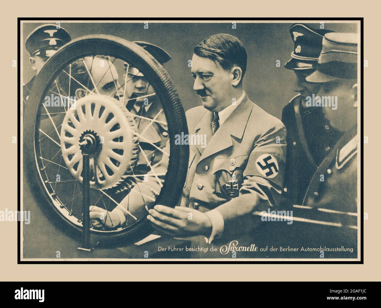 ADOLF HITLER BERLIN MOTORSHOW 1937 Führer il ‘visita la Saxonette al Salone dell'automobile di Berlino' sebbene i motori di attacco per biciclette fossero stati prodotti prima della guerra, il Saxonette help-motor’ era una versione molto raffinata. Sul mercato nel 1938 era essenzialmente il primo di quello che poteva essere descritto come lo stile del ciclomotore del dopoguerra. Il motore montato posteriormente è stato costruito intorno al mozzo Sachs Torpedo, simile alla ruota alata BSA. Questo nuovo design rivoluzionario è stato presentato al pubblico al Salone dell'automobile di Berlino nel 1937. La fabbrica ha fornito il motore già montato sulla ruota. Foto Stock