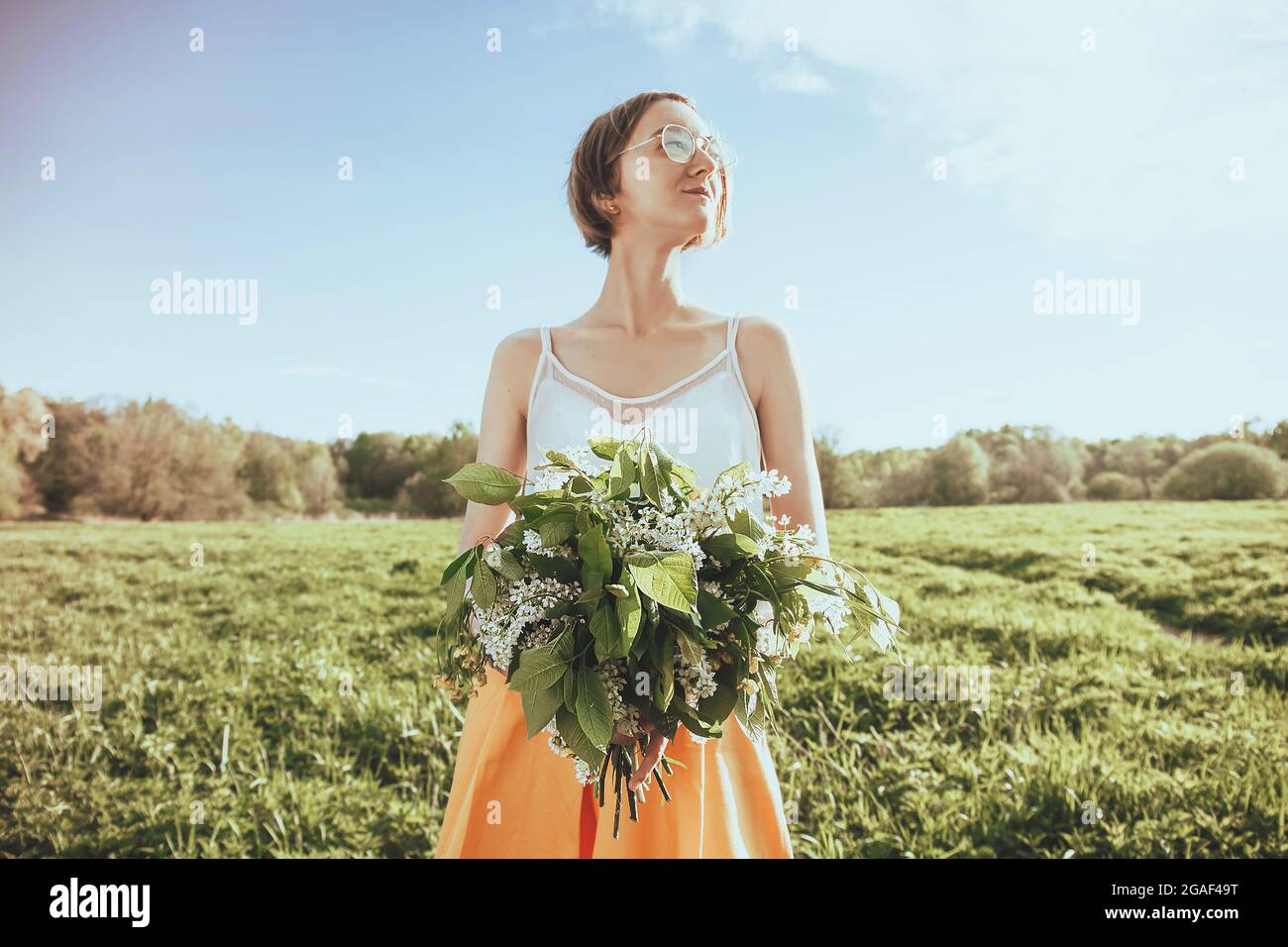 Belle mani femminili che tengono bouquet di fiori selvatici. Ritratto di ragazza con fiori. Sfondo estivo Foto Stock