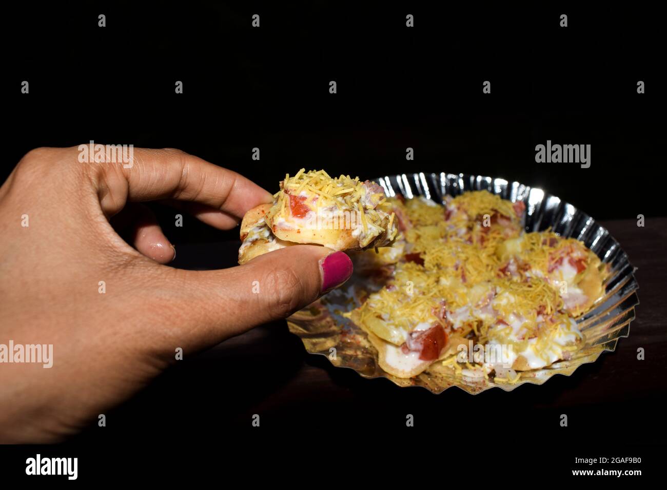Femmina che mangia gustoso cibo indiano, Bhelpuri popolare piatto indiano snack Foto Stock
