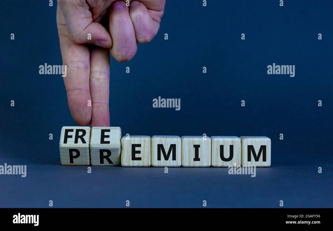 Simbolo Premium o freemium. Uomo d'affari trasforma i cubetti di legno e cambia la parola 'premium' in 'freemium'. Splendido sfondo grigio. Business, premium Foto Stock