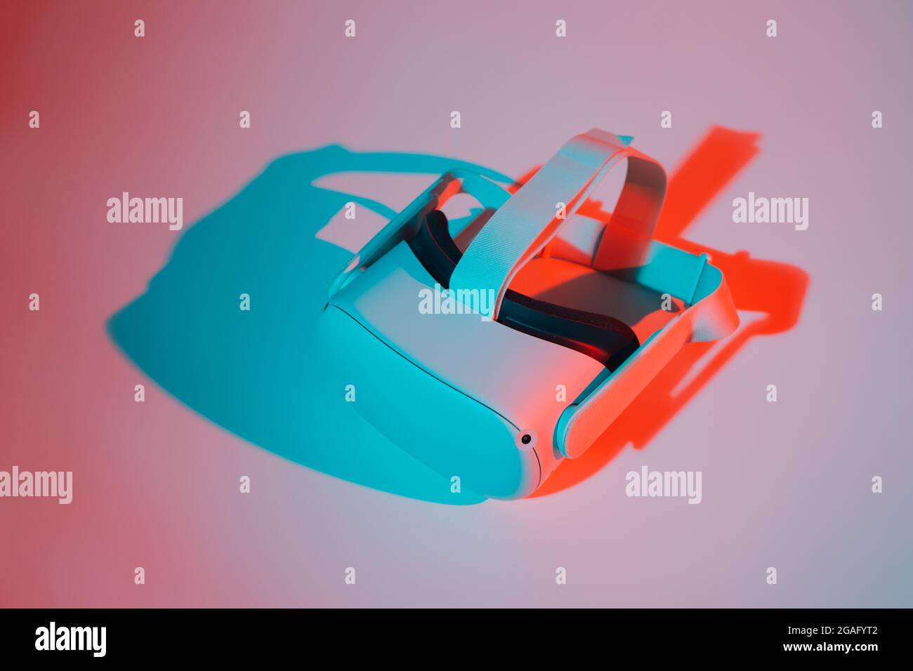 Casco per realtà virtuale su sfondo bianco con luce al neon. Realtà virtuale, futuro, gadget, concetto di tecnologia. Foto Stock