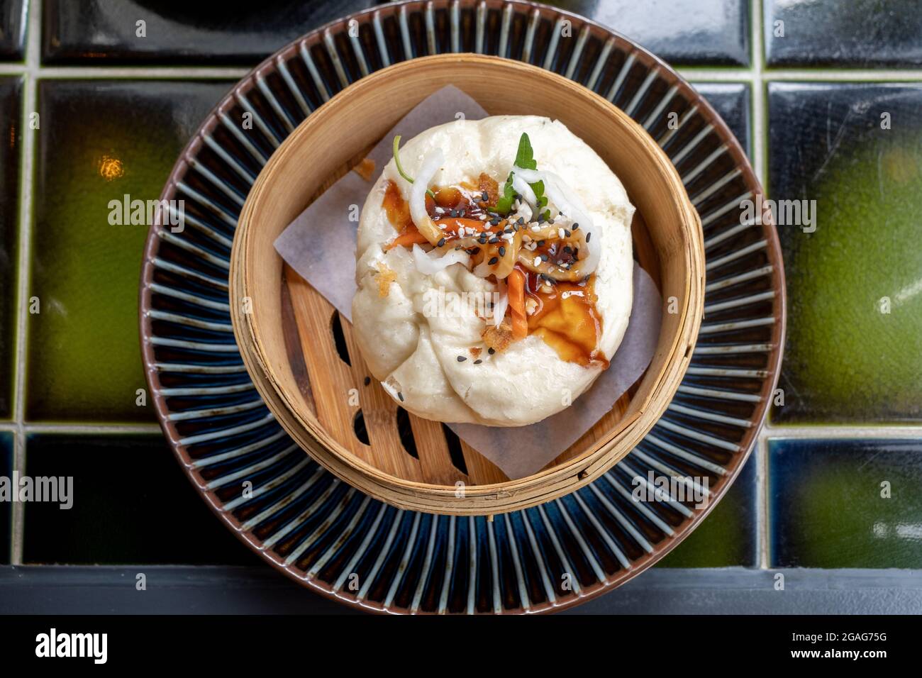 Vista dall'alto di Banh Bao, bocconcino vietnamita con carne di pollo, cipolle e funghi serviti su bambu ruscello. Colazione vietnamita. Foto Stock