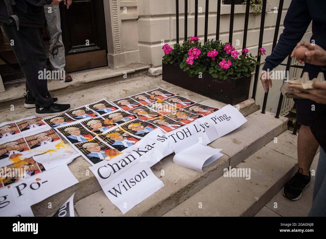 I manifestanti gettano uova sui ritratti autoppressi di tre giudici che hanno fissato il verdetto finale di Tong Ying-kit, di fronte all'Ufficio economico e commerciale di Hong Kong (ETO) a Londra. La signora Justices Esther Toh Lye Ping, Anthea Pang po-kam e Justice Wilson Chan Ka-shun hanno condannato Tong Ying-kit di 24 anni di aver commesso un incitamento alla secessione per il trasporto di un grande banner nero emblonato con lo slogan popolare di protesta anti-governo, 'liberate Hong Kong, rivoluzione dei nostri tempi,' e le attività terroristiche di schiantare il suo motociclo in un gruppo di ufficiali di polizia Foto Stock