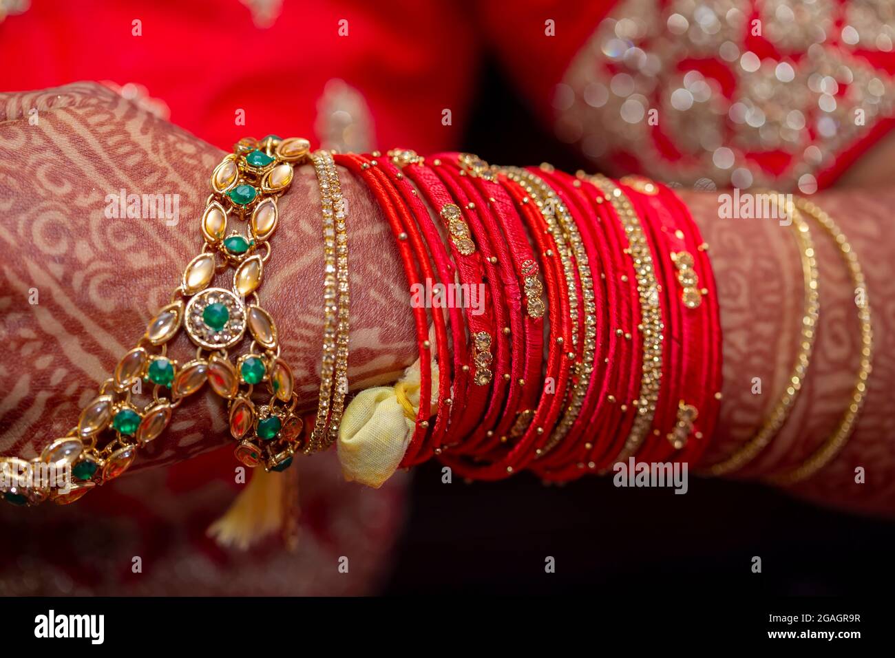 Tradizionali gioielli nuziale e decorazione henné sulle mani della sposa durante una cerimonia religiosa a nozze indù Foto Stock