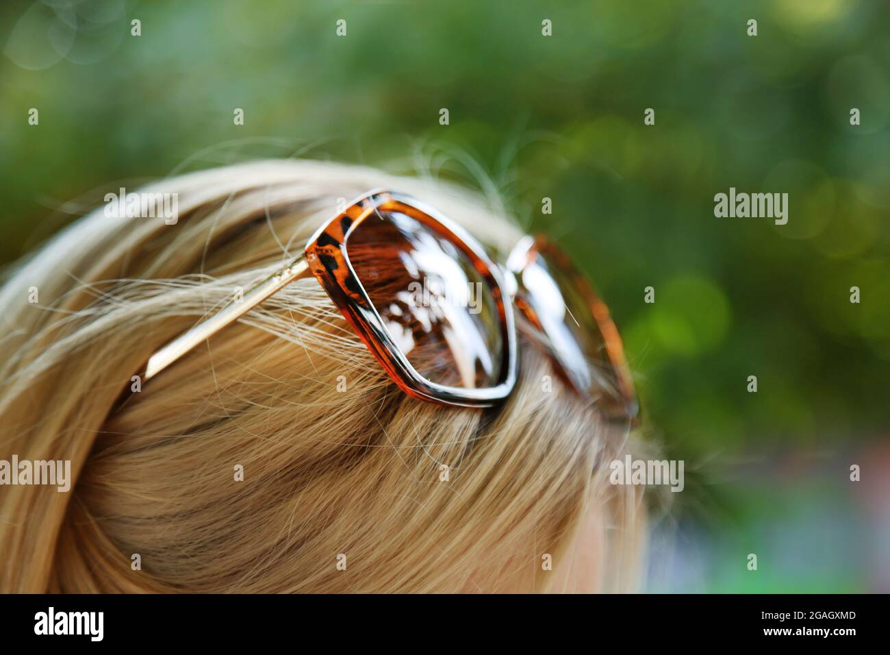 Occhiali sulla testa della ragazza su sfondo naturale Foto stock - Alamy