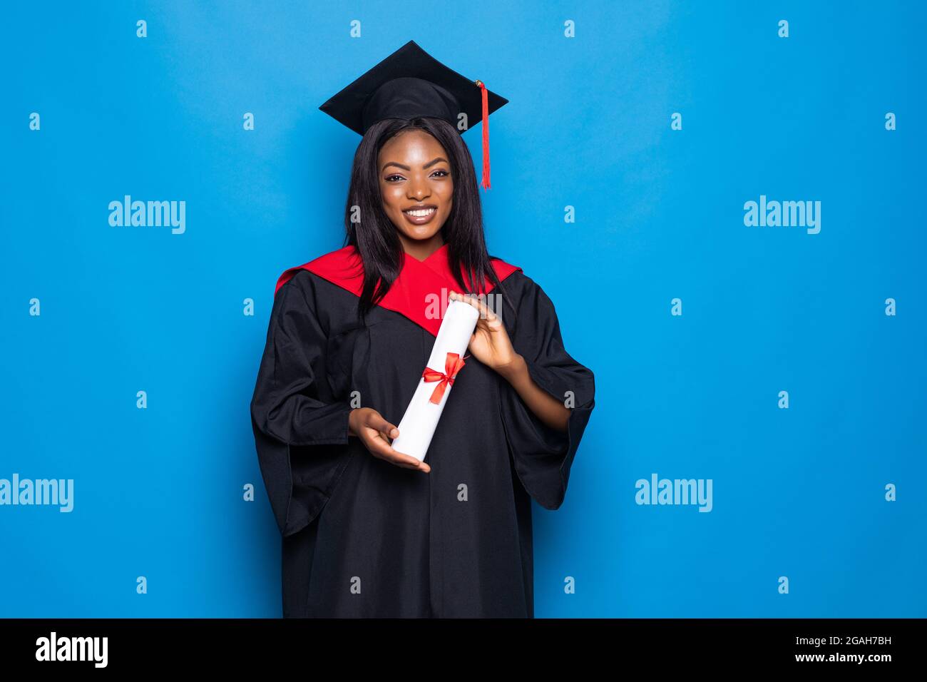 Afroamericana bella donna in un accappatoio e cappello, su sfondo blu  isolato tenendo un diploma di istruzione superiore in mani Foto stock -  Alamy