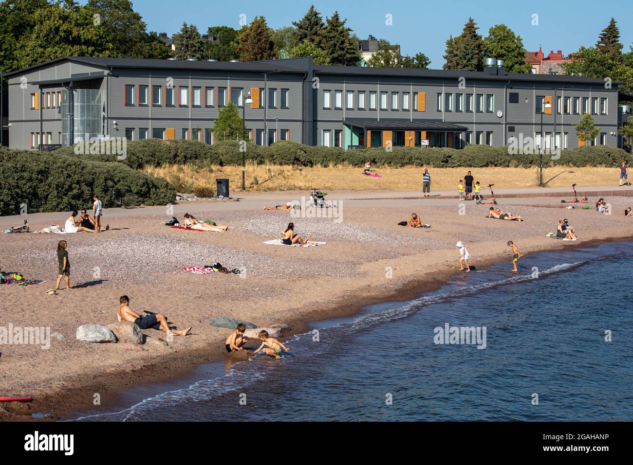 Le persone che godono di una calda serata estiva sulla spiaggia di Eiran ranta a Helsinki, Finlandia Foto Stock