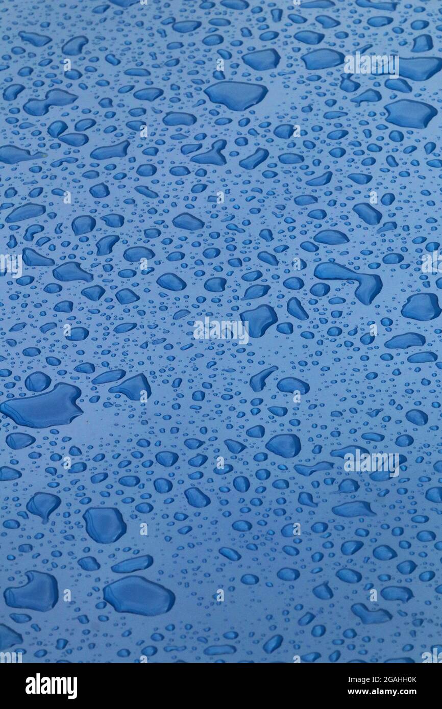 Gocce di acqua sulla superficie blu Foto Stock