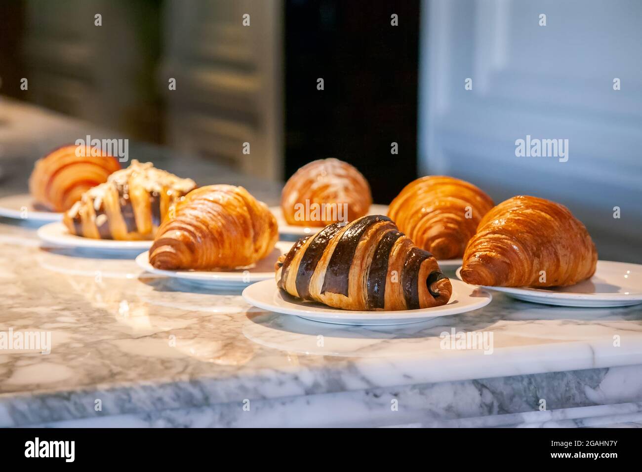 Prima di servire, sul tavolo in marmo vengono posti diversi croissant. Foto Stock