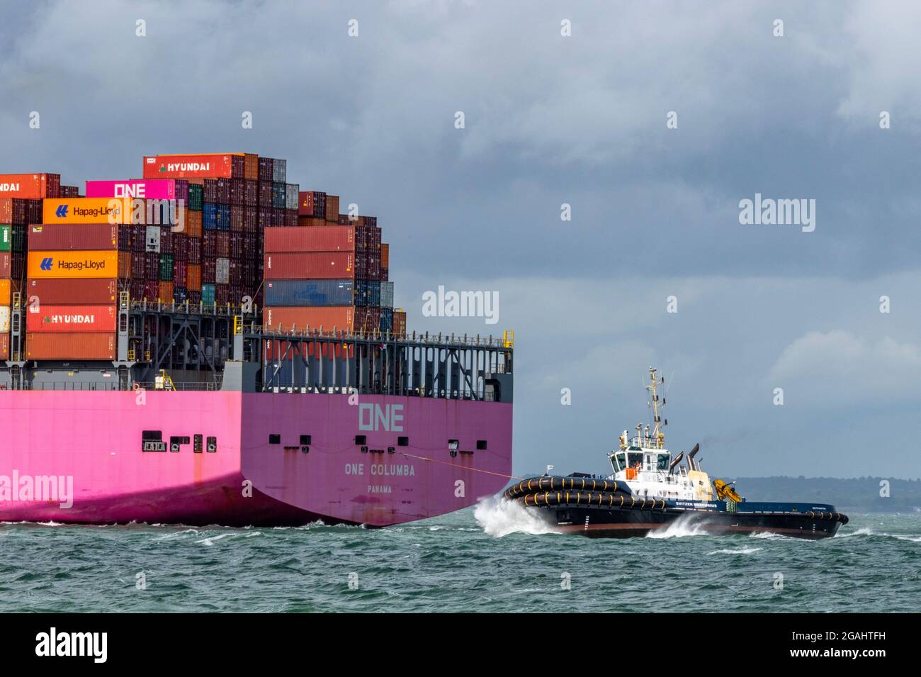Rimorchiatore, One columbia, nave container, nave massiccia, porto di southampton, banchine di southampton, conatinerizzazione. Foto Stock