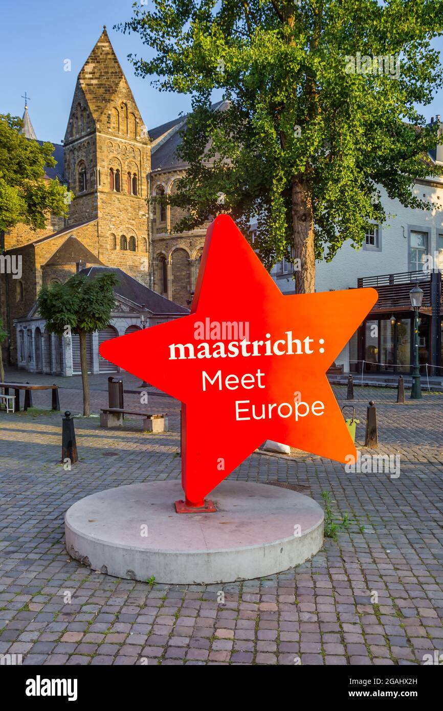 Icona a stella rossa con testo di fronte alla torre della chiesa di Maastricht, Paesi Bassi Foto Stock