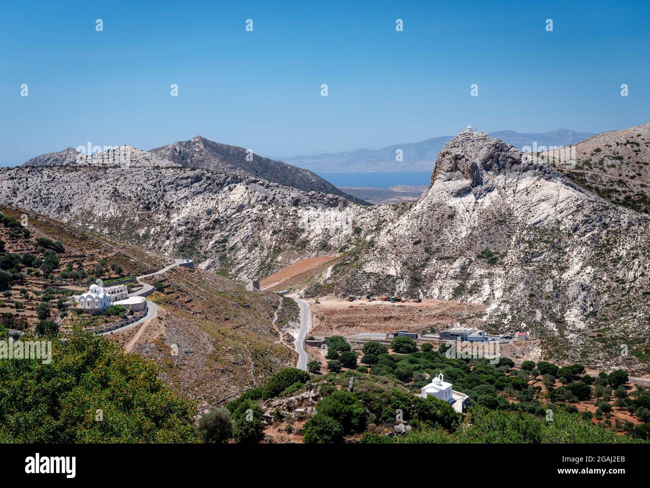 Paesaggio montuoso di Naxos, con pareti bianche cappelle ortodosse orientali e il Mar Egeo sullo sfondo. CICLADI, Grecia. Foto Stock