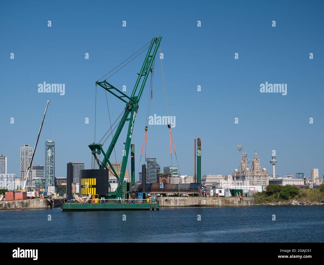 Con il lungomare di Liverpool alle spalle, la gru da 250 tonnellate Skylift 2 che opera sulla sommergibile Skyline Barge 26 a Birkenhead, Regno Unito Foto Stock