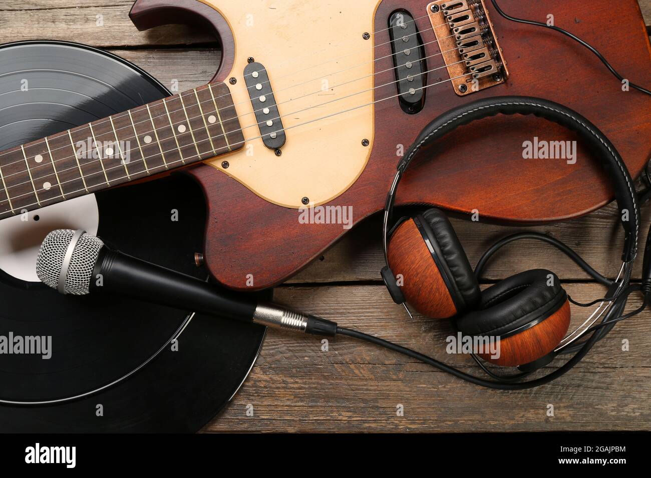 Chitarra elettrica e cuffie con microfono e vinile su sfondo in legno Foto  stock - Alamy