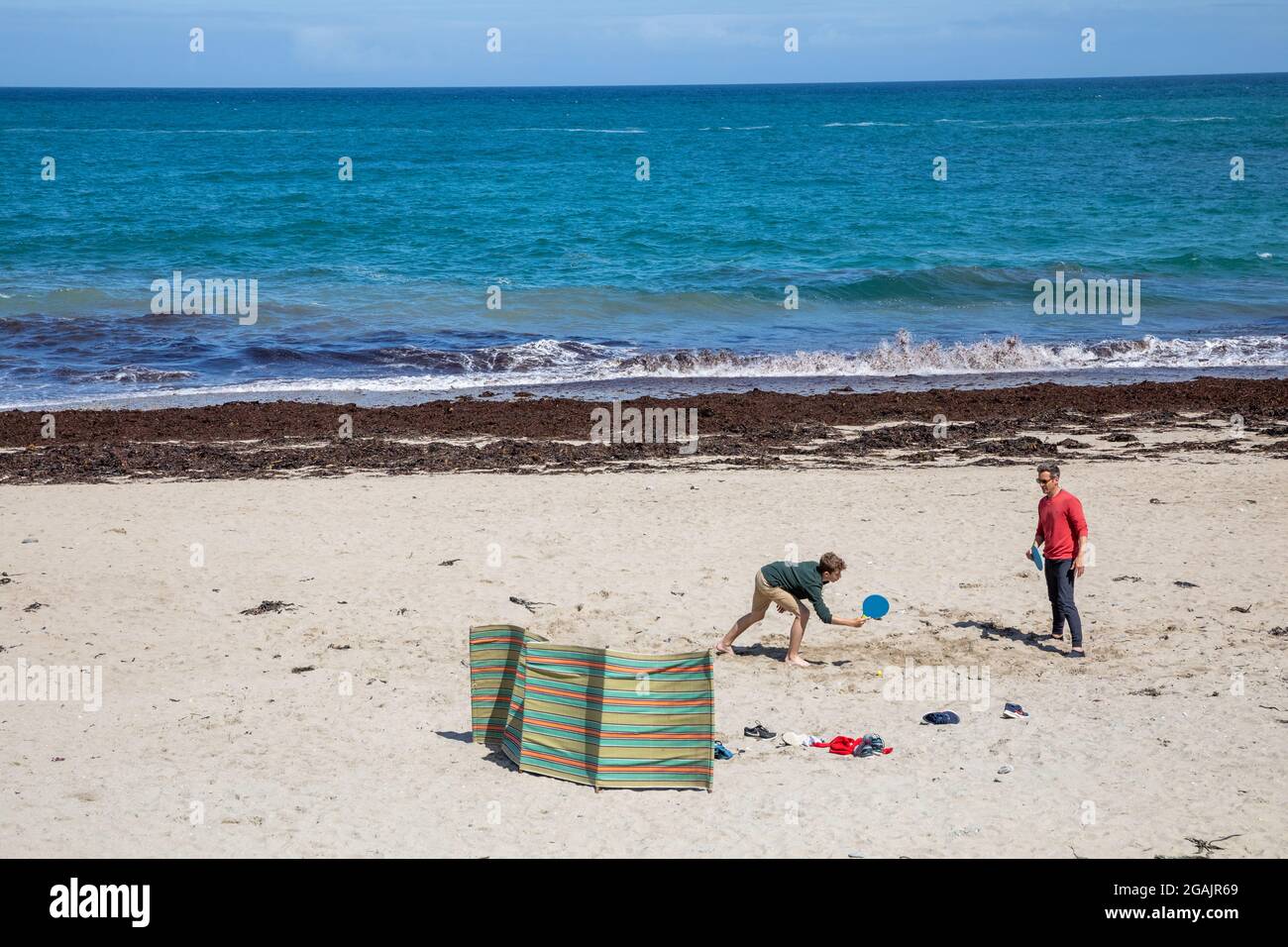 Cornovaglia, Regno Unito. 31 luglio 2021, UN uomo e un ragazzo giocare a pipistrello e palla al sole sulla spiaggia in alta marea a Porteath, Cornovaglia. Tempo non regolato è previsto per i prossimi giorni.Credit: Keith Larby/Alamy Live News Foto Stock