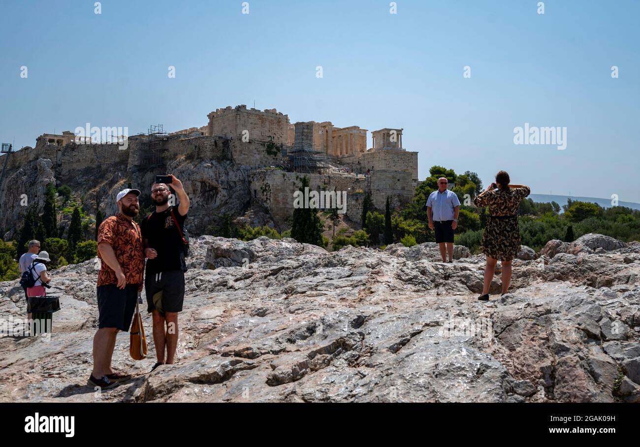 Athen, Grecia. 31 luglio 2021. I turisti visitano la collina Areios Pagos con l'Acropoli sullo sfondo a temperature superiori ai 40 gradi. I violenti incendi boschivi e il calore continuo di 40 gradi e più rendono i paesi di vacanza del sud difficili da affrontare. Secondo i meteorologi, la Grecia prevede temperature fino a 46 gradi. Credit: Angelos Tzortzinis/dpa/Alamy Live News Foto Stock