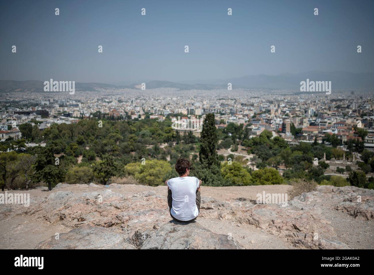 Athen, Grecia. 31 luglio 2021. Un turista si affaccia sulla città a temperature superiori ai 40 gradi sulla collina Areios Pagos. Incendi boschivi feroci e calore continuo di 40 gradi e più stanno dando ai paesi di vacanza del sud un momento duro. Secondo i meteorologi, la Grecia prevede temperature fino a 46 gradi. Credit: Angelos Tzortzinis/dpa/Alamy Live News Foto Stock